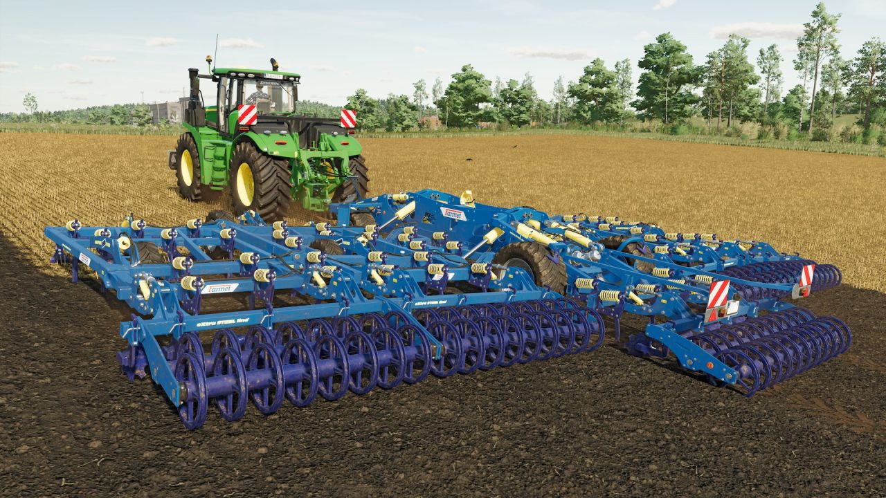 Platino di Farming Simulator 22: un trattore con un grosso coltivatore sul campo arato